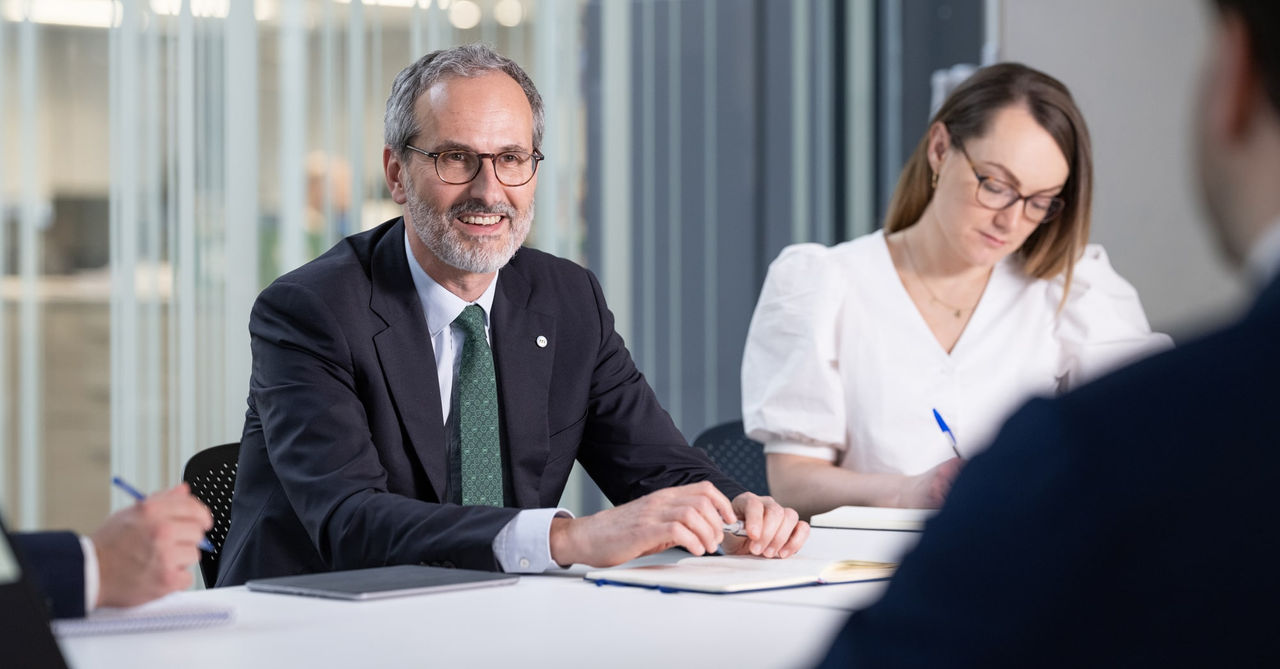 Christophe Jaubert lächelt beim Treffen mit anderen Mediolanum-Mitarbeitern